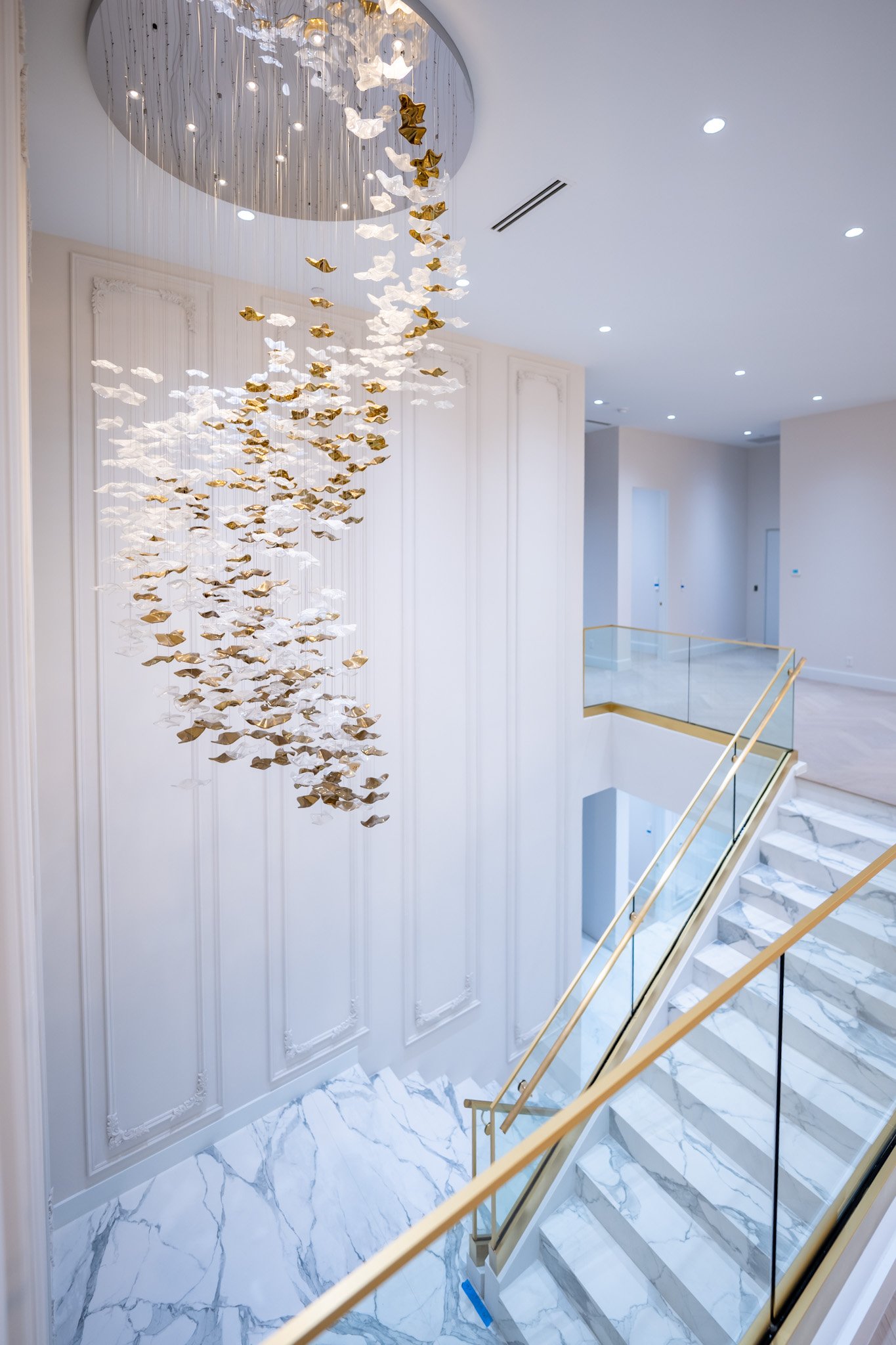 Two-story staircase with cascading chandelier, Joelene home in Euro Chic